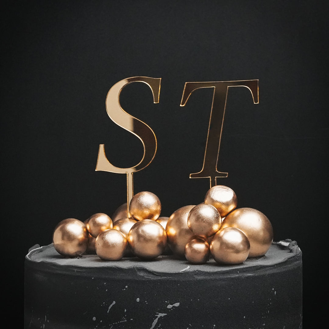 Gold ST initials cake topper on a celebration cake